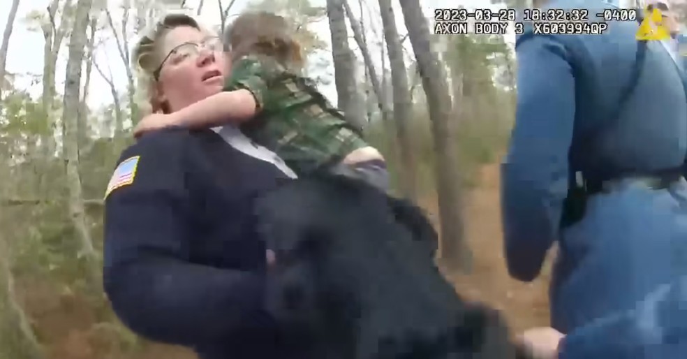 Garoto de quatro anos é encontrado com seu cachorro após se perder em floresta dos EUA; na imagem acima, a mãe abraça o menino enquanto o cão labrador deles se aproxima — Foto: reprodução
