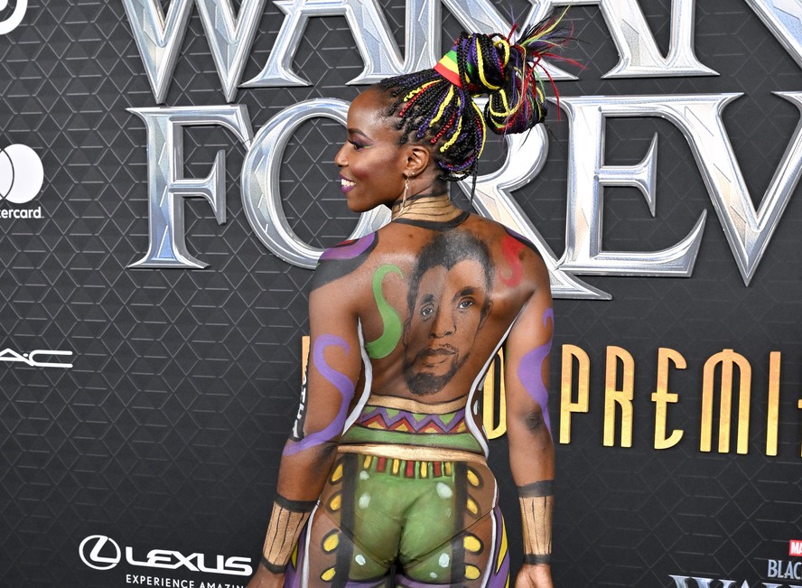 Atriz Janeshia Adams-Ginyard posa só de pintura corporal e homenageia Chadwick Boseman (1976-2020) com desenho nas costas na première de 'Pantera Negra 2' (2022)