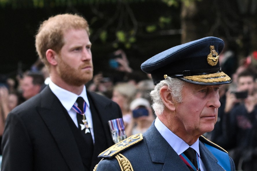 O Rei Charles III com seu uniforme militar e o Príncipe Harry em vestimentas civis