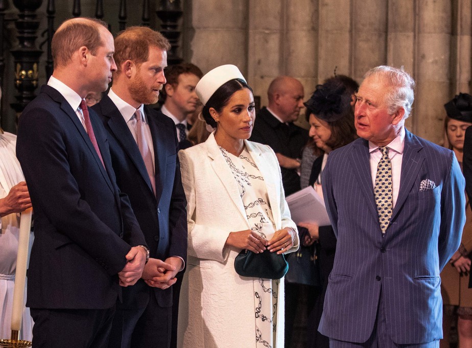 O Rei Charles III na companhia dos filhos, Príncipe William e Príncipe Harry, e da atriz e Duquesa Meghan Markle, em foto de março de 2019