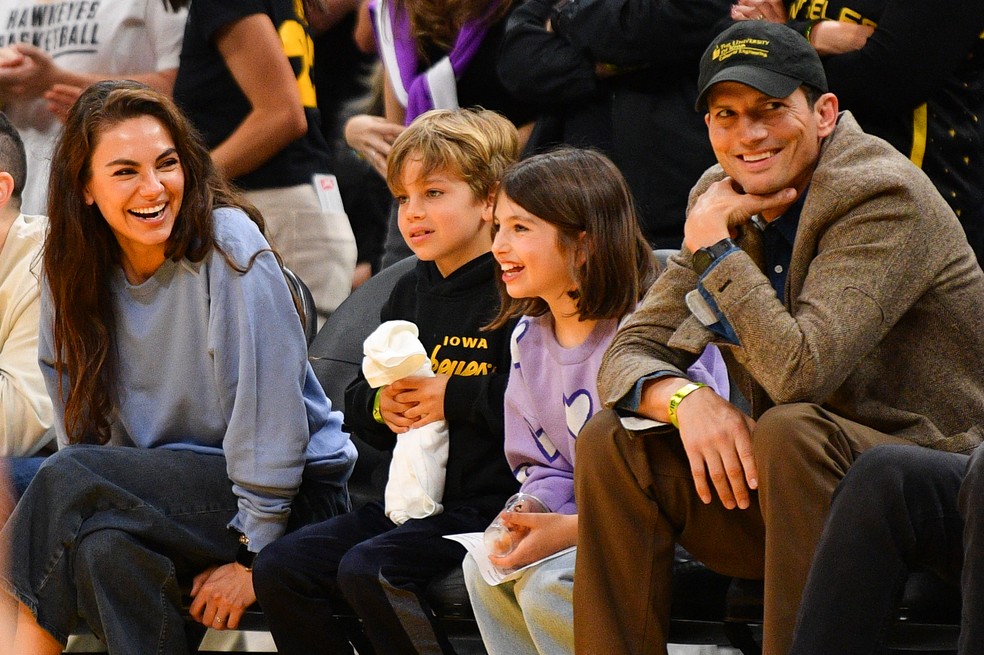 O ator Ashton Kutcher e a atriz Mila Kunis com os filhos, Wyatt e Dimitri, em jogo de basquete da WNBA — Foto: Getty Images