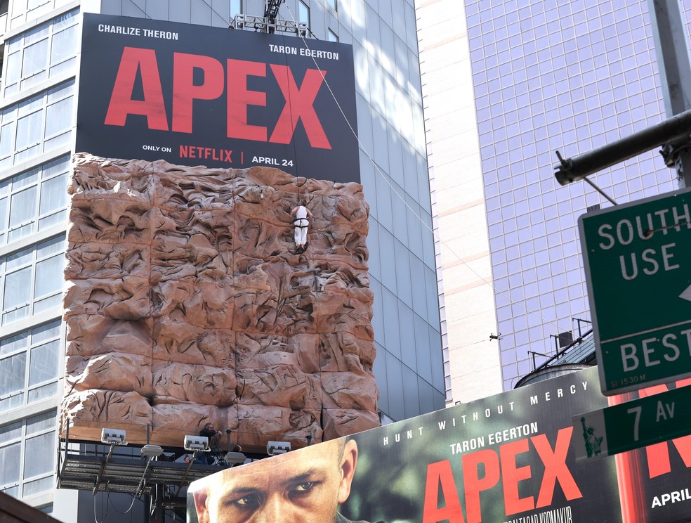 Charlize Theron escalando outdoor na Times Square — Foto: Getty