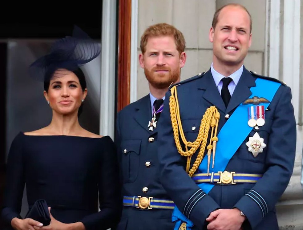 O Príncipe Harry e a atriz e Duquesa Meghan Markle na companhia do Príncipe William antes da renúncia do casal às suas funções na realeza britânica — Foto: Getty Images