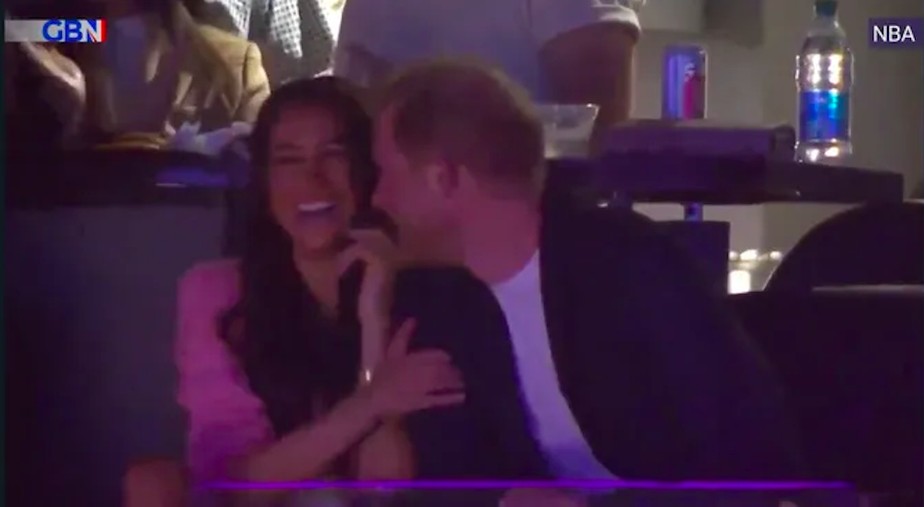 Meghan Markle rindo após recusar a tentativa de beijo do marido, o Príncipe Harry, em partida da NBA
