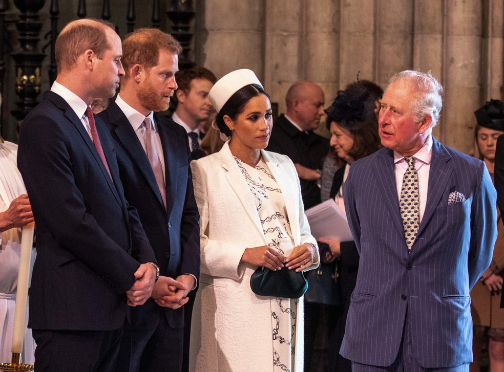 O Rei Charles III na companhia dos filhos, Príncipe William e Príncipe Harry, e da atriz e Duquesa Meghan Markle, em foto de março de 2019 — Foto: Getty Images