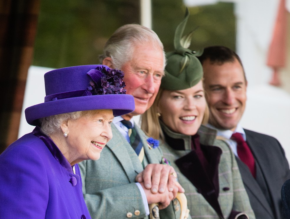 A Rainha Elizabeth II (1926-2022) com o então Príncipe Charles e o neto, Peter Phillips, com a ex-esposa em foto de 2019 — Foto: Getty Images