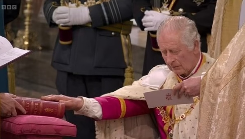 Rei Charles III lendo um cartão com suas falas durante juramento em coroação — Foto: Reprodução