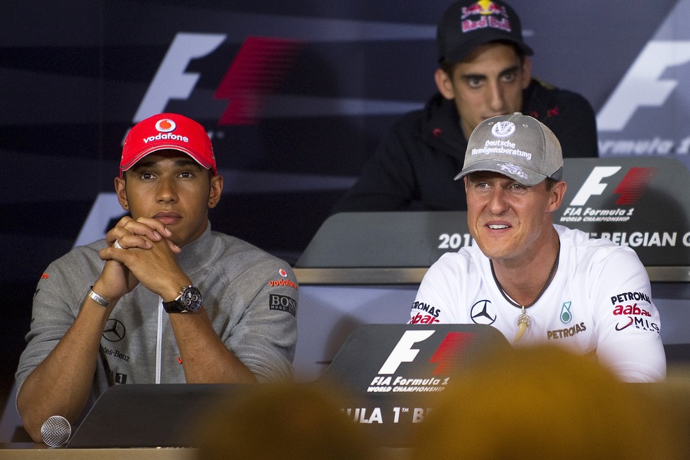 Nesta foto de arquivo tirada em 26 de agosto de 2010, o piloto britânico Lewis Hamilton e o piloto alemão Michael Schumacher participam de uma coletiva de imprensa no circuito de Spa-Francorchamps em Spa, três dias antes do Grande Prêmio da Bélgica de Fórmula 1. — Foto: Getty Images