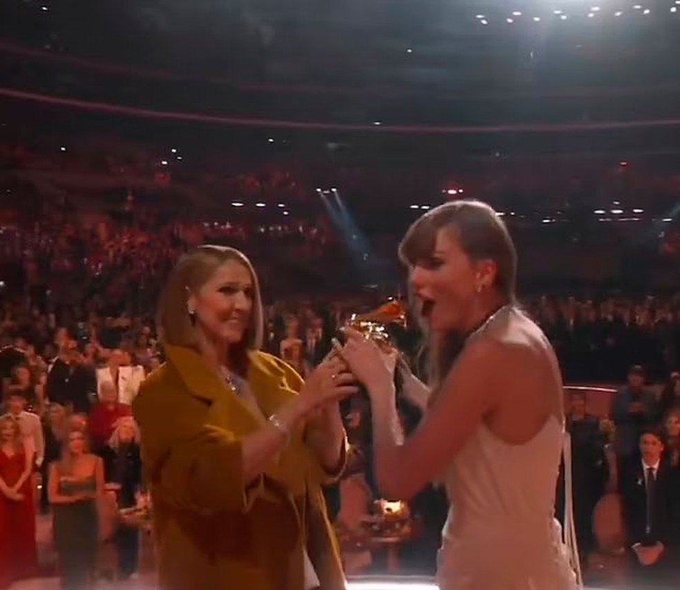 Taylor Swift pega o Grammy das mãos de Céline Dion olhando para os seus amigos e parceiros musicais — Foto: reprodução