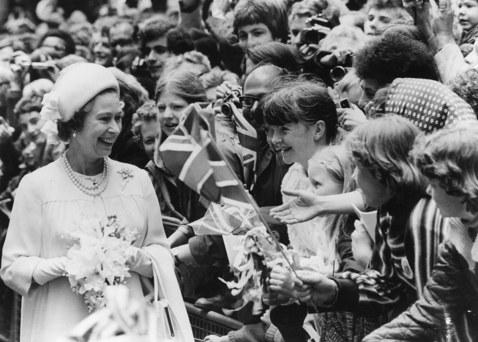 Rainha Elizabeth II rindo com uma multidão de crianças durante as celebrações de seu Jubileu de Prata, em 1977 — Foto: Getty Images