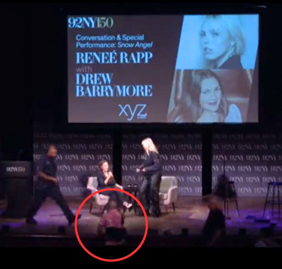 Drew Barrymore pouco antes de levantar para deixar o palco com a aproximação do stalker, circulado em vermelho — Foto: Reprodução