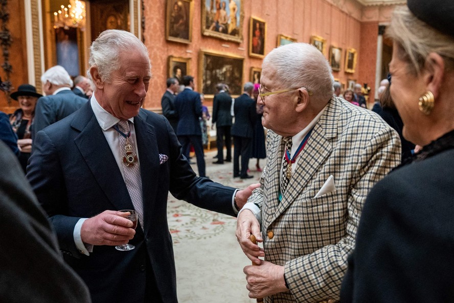 O rei Charles III conversa com o artista David Hockney durante um almoço para membros da Ordem de Mérito, no Palácio de Buckingham, em Londres, em 24 de novembro de 2022