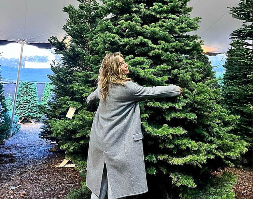 Jennifer Aniston abraçando o pinheiro que comprou para decorar sua casa no Natal de 2022
