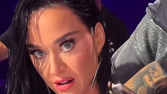 Top de Katy Perry quebra durante gravação de programa de TV e ela se esconde atrás de mesa