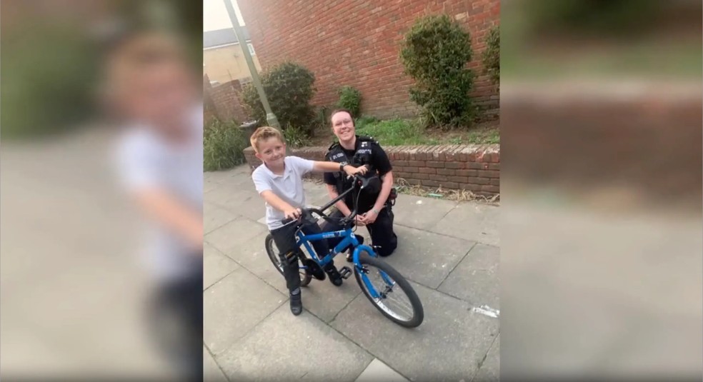 Policial posa ao lado de menino que emprestou bicicleta para perseguição — Foto: reprodução/twitter