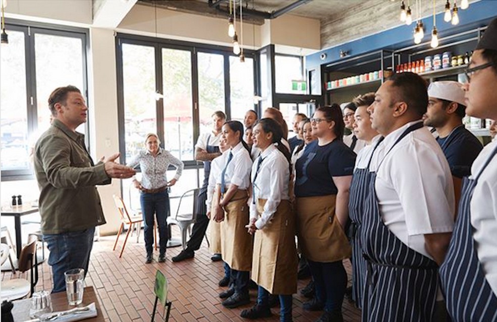 O chef e apresentador de TV Jamie Oliver com funcionários de uma unidade de seu restaurante — Foto: Instagram