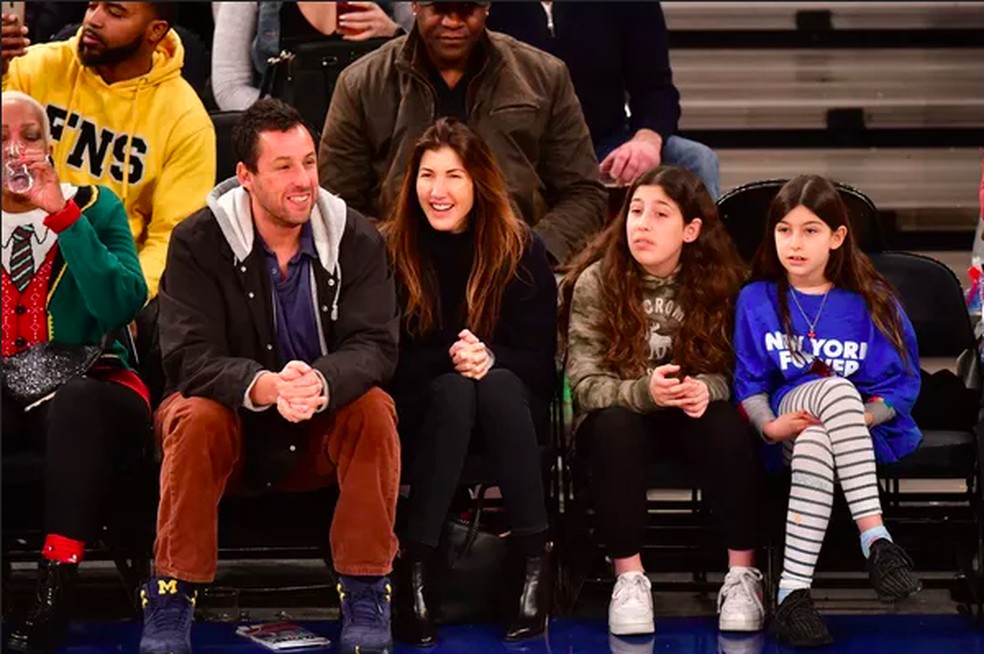 Adam Sandler com a esposa e as filhas em um jogo de basquete — Foto: Getty Images