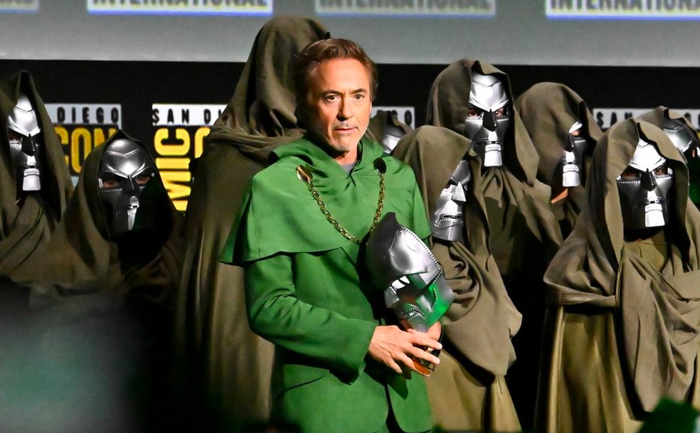 O ator Robert Downey Jr. com a máscara do vilão Doutor Destino no evento anunciando seu retorno à Marvel — Foto: Getty Images