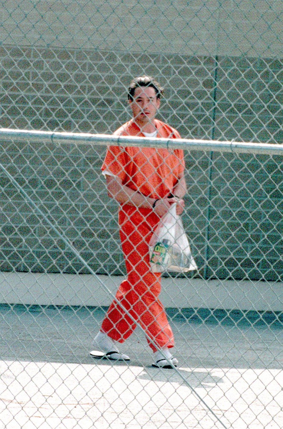  O ator Robert Downey, Jr. a caminho de um ônibus da prisão após sua audiência em 5 de agosto de 1999 em Malibu, Califórnia — Foto: Getty Images