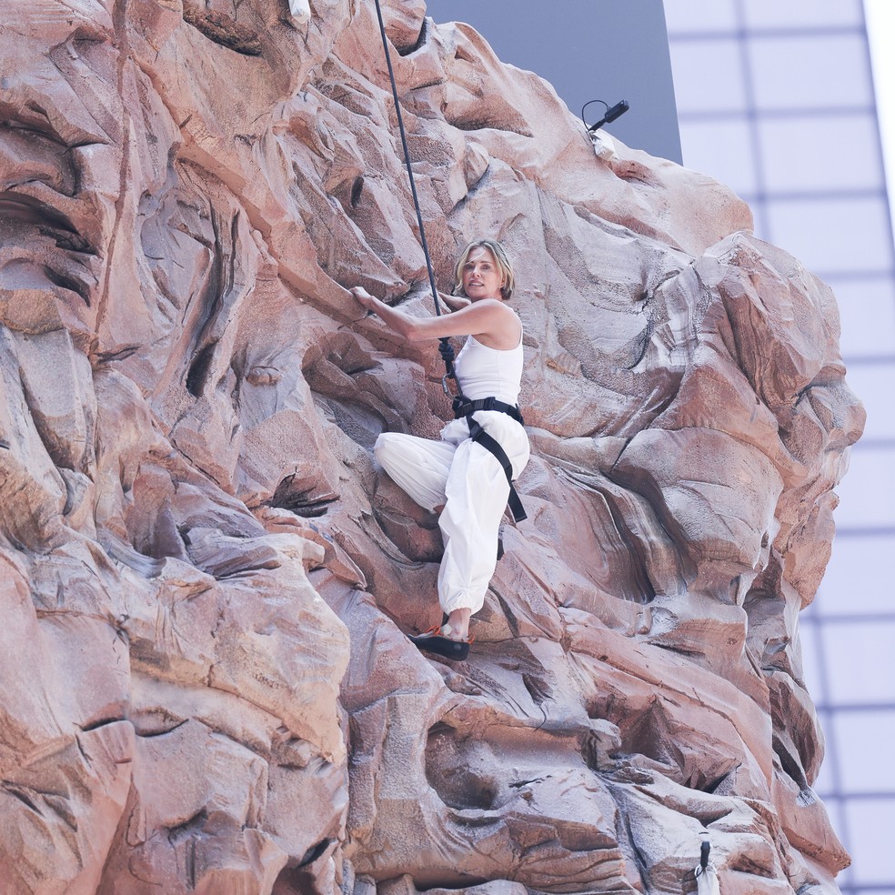 Charlize Theron escalando outdoor na Times Square — Foto: Getty